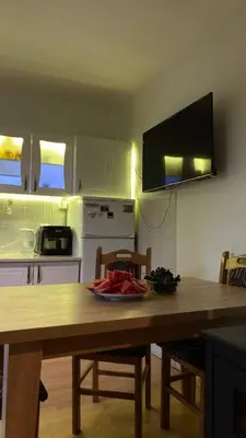 a kitchen with a wooden table with chairs and a tableablish at Cozy House Belgrade in Kalugjerica