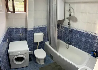 a bathroom with a toilet and a tub and a sink at Cozy House Belgrade in Kalugjerica