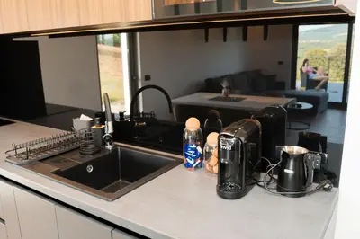 a kitchen counter with a sink and a living room at Kosmaj Sunrise in Rogača