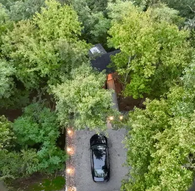 an aerial view of a car parked in a parking lot between trees at Furo Treehouse in Barajevo