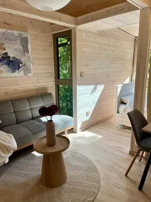 a living room with a couch and a table at Furo Treehouse in Barajevo