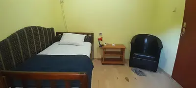 a small bedroom with a bed and a chair at Airport Guesthouse Rooms and Apartmants in Beograd