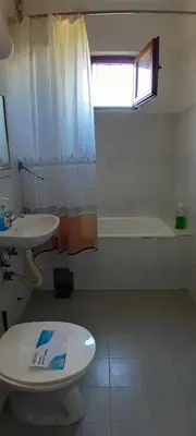 a bathroom with a toilet and a sink and a tub at Airport Guesthouse Rooms and Apartmants in Beograd