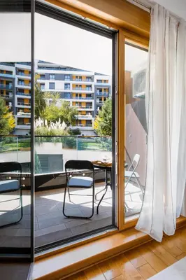 a room with a balcony with a table and chairs at Central Garden Apartment - Parking & Security in Belgrade
