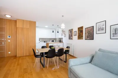 a living room with a table and chairs and a couch at Central Garden Apartment - Parking & Security in Belgrade