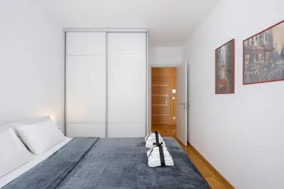 a bedroom with a large bed with a blue rug at Central Garden Apartment - Parking & Security in Belgrade
