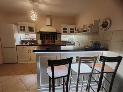 a kitchen with two chairs at a kitchen island at ART HOUSE Kosmaj 1 in Sopot