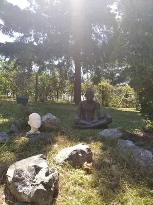 a statue of a person sitting on the grass at ART HOUSE Kosmaj 1 in Sopot