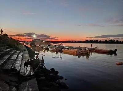 a man standing next to a dock with boats in the water at Katera S in Zemun