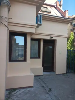 a white house with a door and a fence at Katera S in Zemun