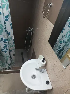 a bathroom with a sink and a shower with a mirror at Katera S in Zemun