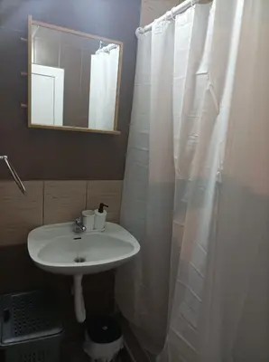 a bathroom with a sink and a shower curtain at Katera S in Zemun