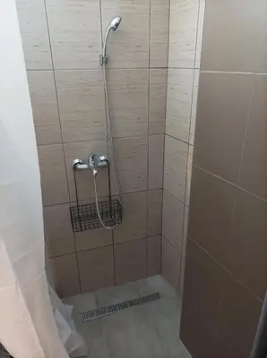 a shower stall with a shower curtain and a shower at Katera S in Zemun