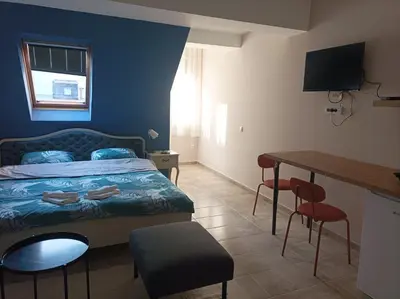 a bedroom with a bed and a table and chairs at Katera S in Zemun