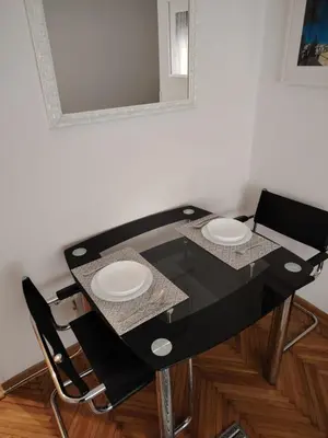 a black dining room table with two white plates on it at Apartment 20 in Belgrade