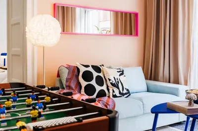 a living room with a blue couch and a table at Velvet Stay 120m2 with Foosball Old Town in Belgrade