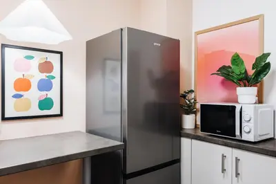 a kitchen with a stainless steel refrigerator and a microwave at Velvet Stay 120m2 with Foosball Old Town in Belgrade