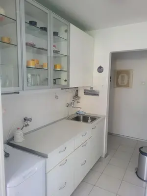 a kitchen with white cabinets and a sink at ML Apartman in Belgrade