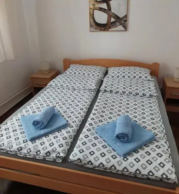 a bed with two blue towels sitting on it at msapartman in Surčin