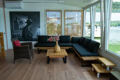 a living room with a couch and a table at Unique River Houseboat Stay in Železnička Stanica Senjak
