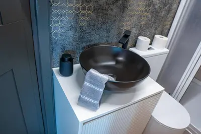 a bathroom with a black sink on top of a vanity at Unique River Houseboat Stay in Železnička Stanica Senjak