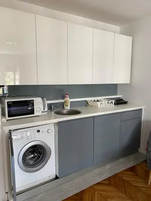 a kitchen with a washing machine and a microwave at Apartment Silver Pedestrian Zone in Belgrade