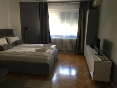 a bedroom with a bed and a window with a television at Apartment Silver Pedestrian Zone in Belgrade