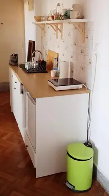 a kitchen with a counter with a green stool at Mansard Crimson Rhapsody in Belgrade