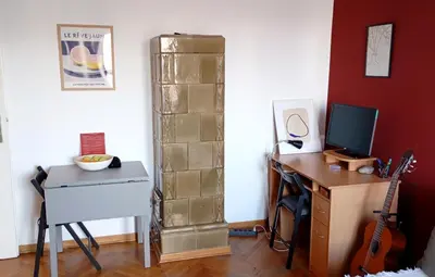 a room with a desk with a computer and a guitar at Mansard Crimson Rhapsody in Belgrade