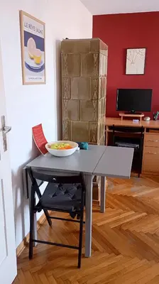 a table with a bowl of fruit on it in a room at Mansard Crimson Rhapsody in Belgrade