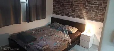 a bedroom with a bed and a brick wall at Point apartman 1 in Belgrade