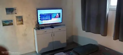 a flat screen tv on top of a white cabinet at Point apartman 1 in Belgrade