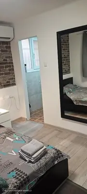 a room with a mirror and a bed with towels at Point apartman 1 in Belgrade