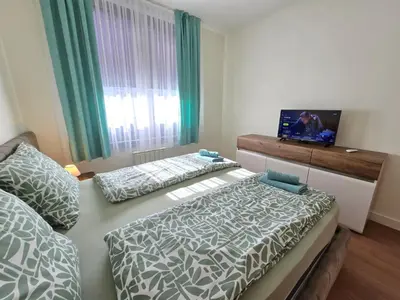 a bedroom with two beds and a tv on the wall at BW Quartet 303 deluxe apartments in Belgrade