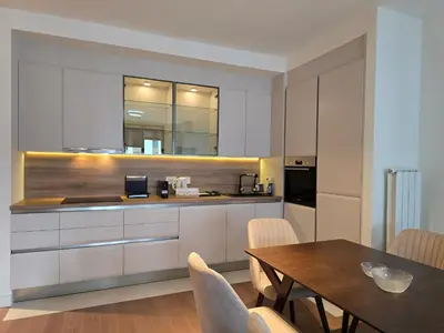 a kitchen with white cabinets and a table with chairs at BW Quartet 303 deluxe apartments in Belgrade