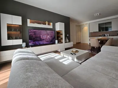 a living room with a couch and a large screen tv at BW Quartet 303 deluxe apartments in Belgrade