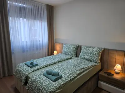 a small bedroom with a bed with blue pillows at BW Quartet 303 deluxe apartments in Belgrade