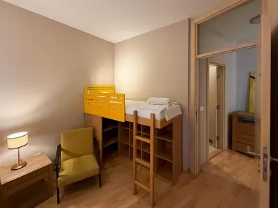 a small room with a bunk bed and a chair at Downtown family apartment in Belgrade