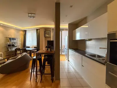 a kitchen and living room with a table and a couch at Downtown family apartment in Belgrade