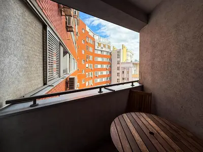 a balcony with a wooden bench and a window at Downtown family apartment in Belgrade