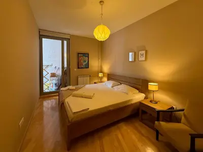 a bedroom with a large bed and a window at Downtown family apartment in Belgrade