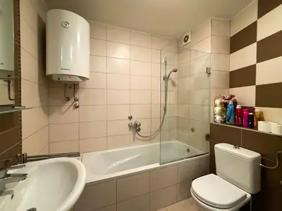 a bathroom with a tub and a toilet and a sink at Downtown family apartment in Belgrade