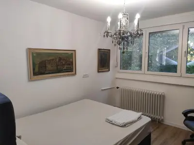 a white room with a table and a chandelier at Nela Lux in Belgrade