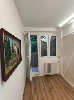 a room with a painting on the wall and two windows at Nela Lux in Belgrade