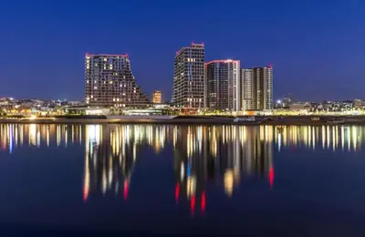 a city skyline at night with its reflection in the water at BW QUARTET Apartman-whit free garage parking in Belgrade