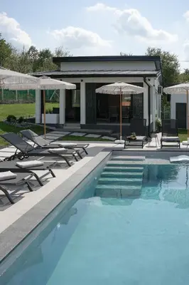 a swimming pool with lounge chairs and umbrellas at Aeri Nature Concept in Baljevac