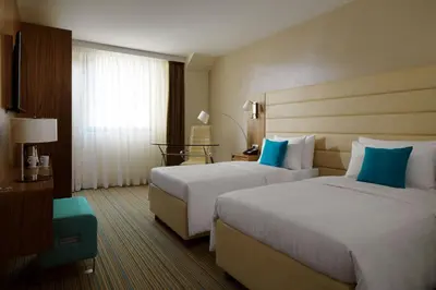 a hotel room with two beds and a window at Courtyard by Marriott Belgrade City Center in Belgrade