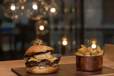 a cheeseburger and a bucket of fries on a table at Courtyard by Marriott Belgrade City Center in Belgrade