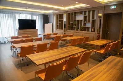 a classroom with tables and chairs and a flat screen tv at Courtyard by Marriott Belgrade City Center in Belgrade
