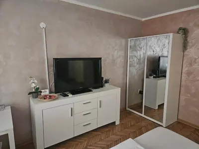 a living room with a television on a white cabinet at Room Nine in Belgrade